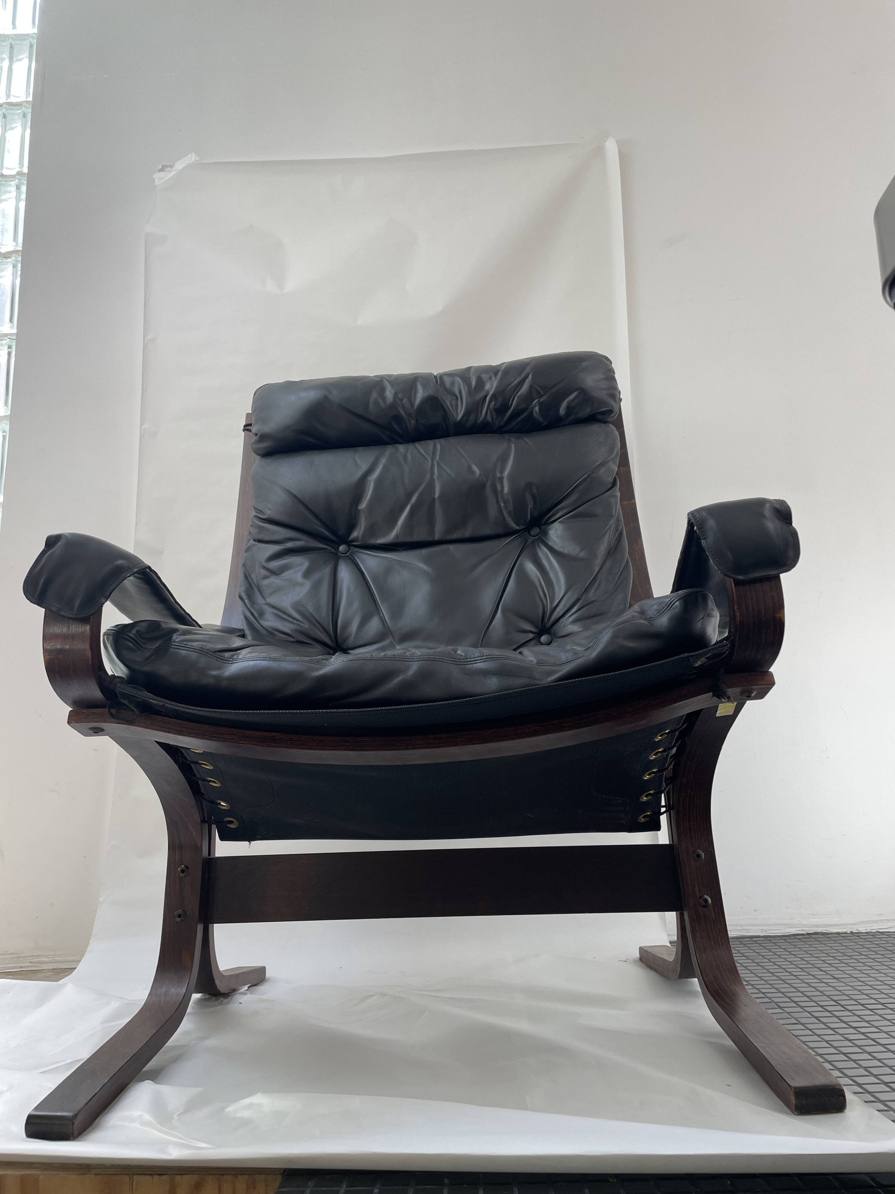 Fauteuil et repose pied Siesta en cuir noir et bois acajou