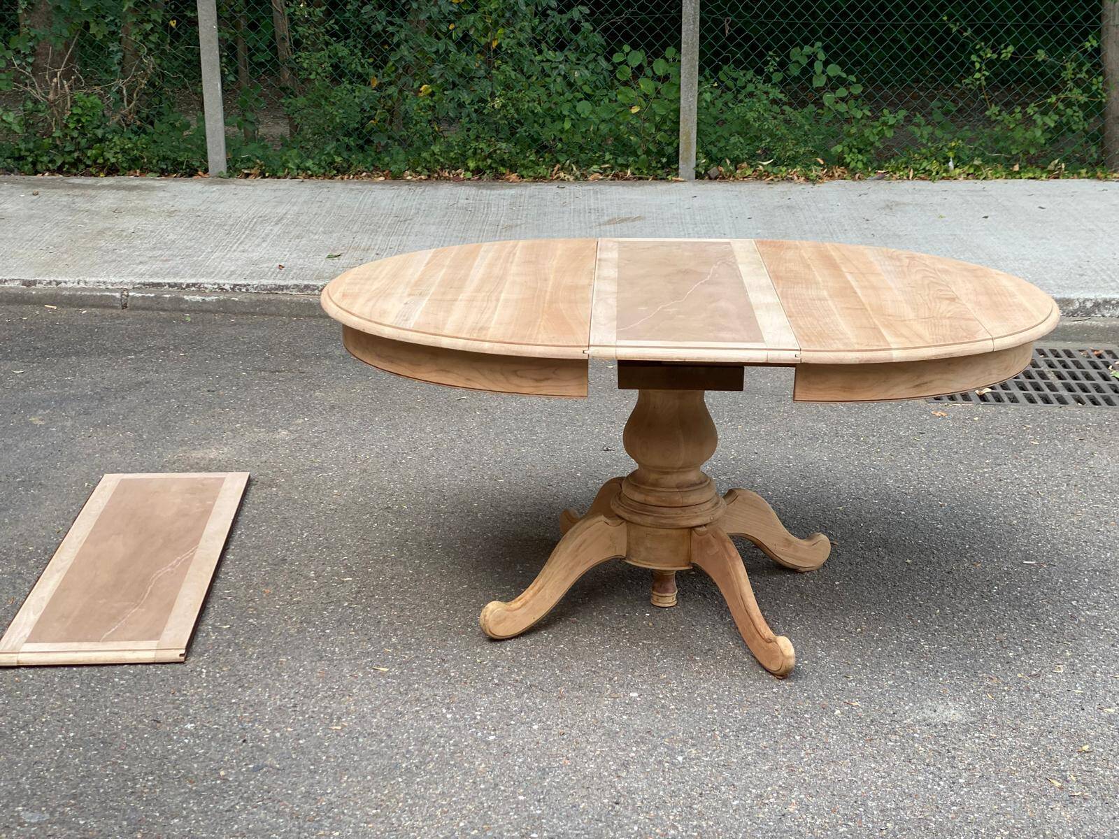 Round dining table with a central pedestal, extendable, stripped in solid walnut with 2 extensions.