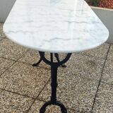 White and black oval marble table, wrought iron base