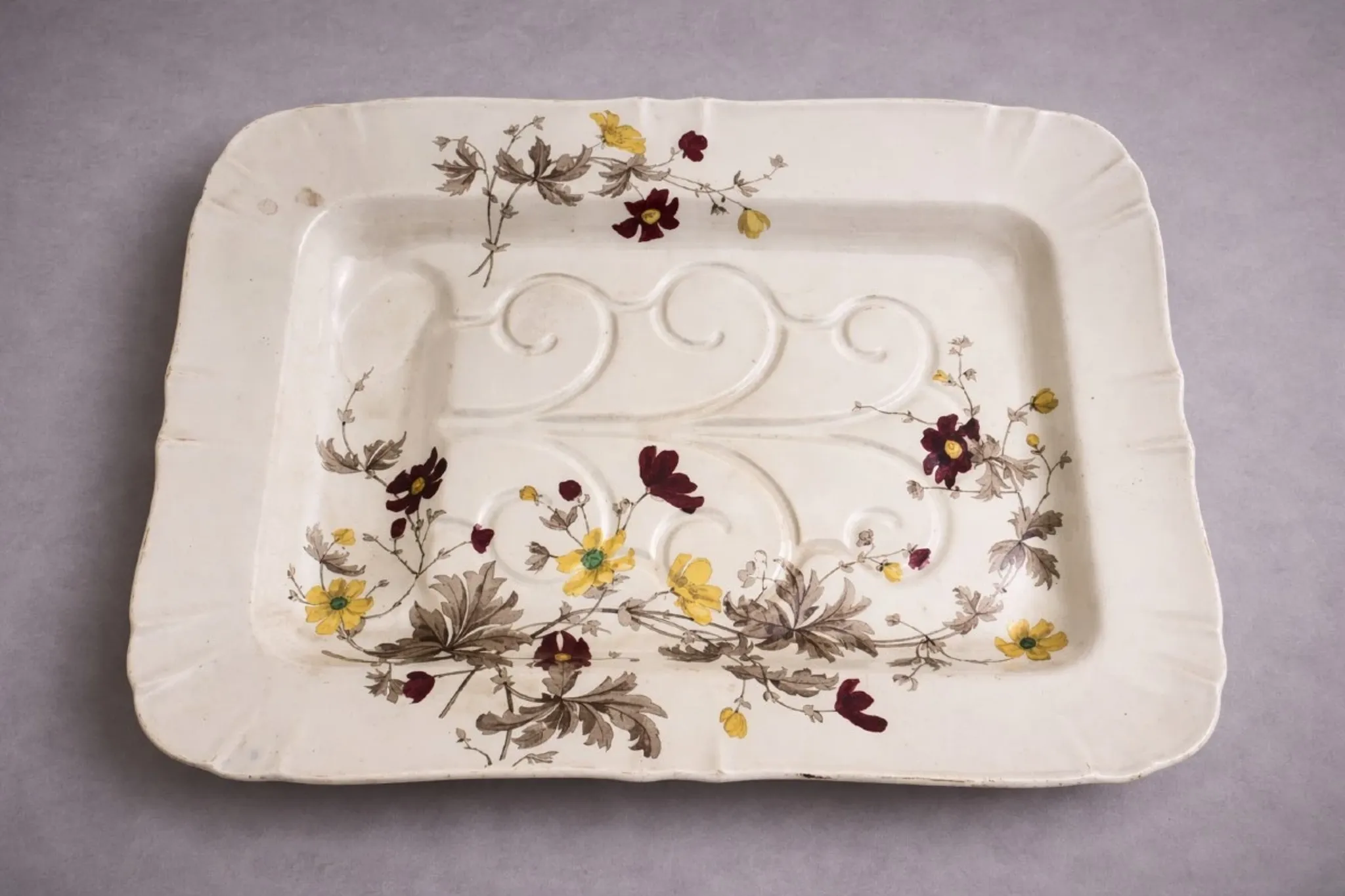 Very large rectangular dish with scalloped edges, made of fine glazed earthenware.