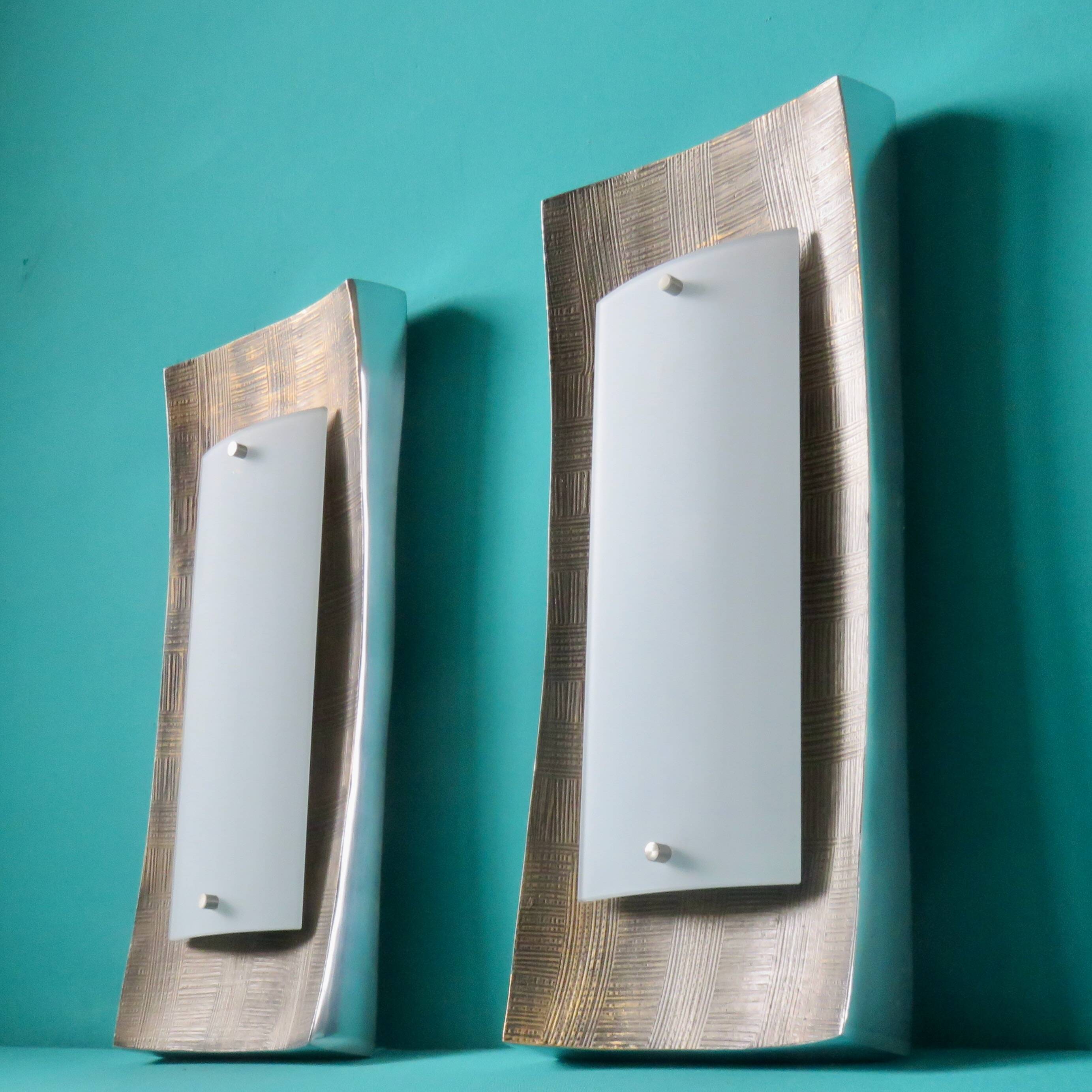 Pair of wall sconces in gold-plated alloy with bas-relief and opaline glass. Germany, 1980