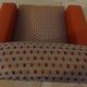 Vintage rockabilly retro armchair in orange faux leather and fabric.