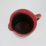 Red glazed ceramic jug with relief