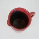 Red glazed ceramic jug with relief