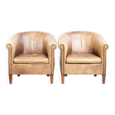 Ensemble de deux fauteuils club en cuir de vache vintage de style anglais.
