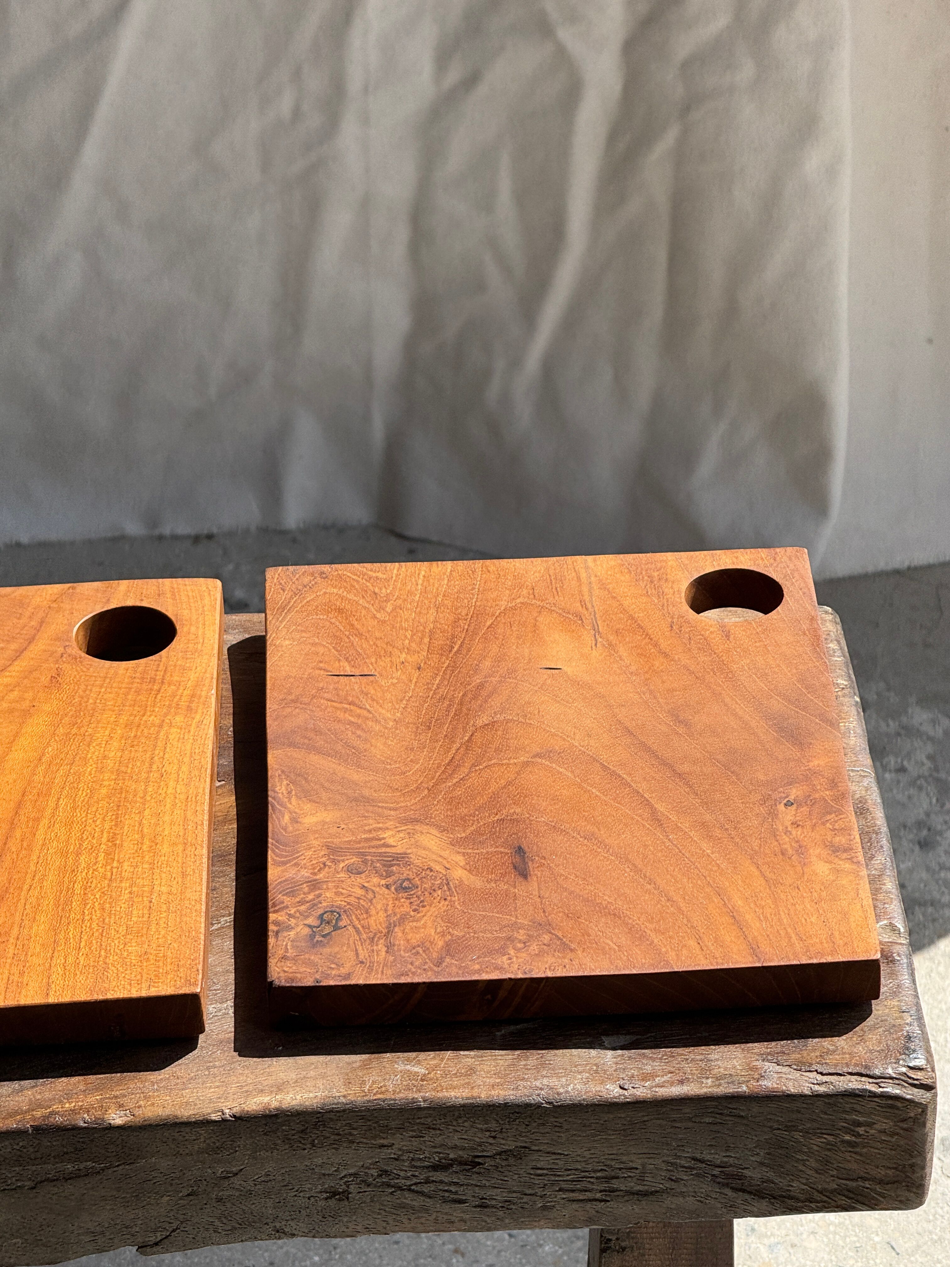 Small rectangular teak monoxyle cutting board with a circular handle.