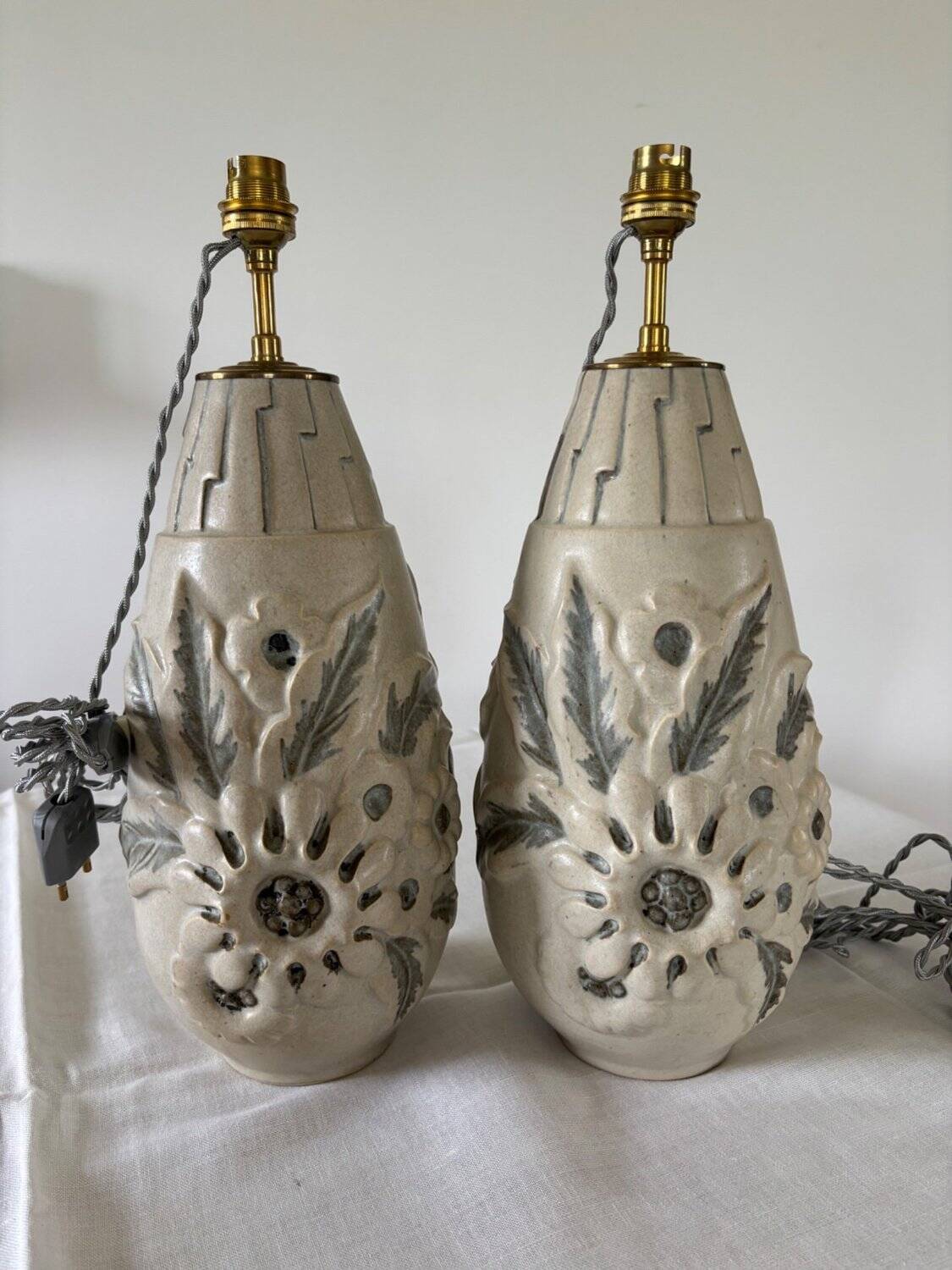 Pair of white glazed stoneware lamp bases, 20th-century floral decoration.