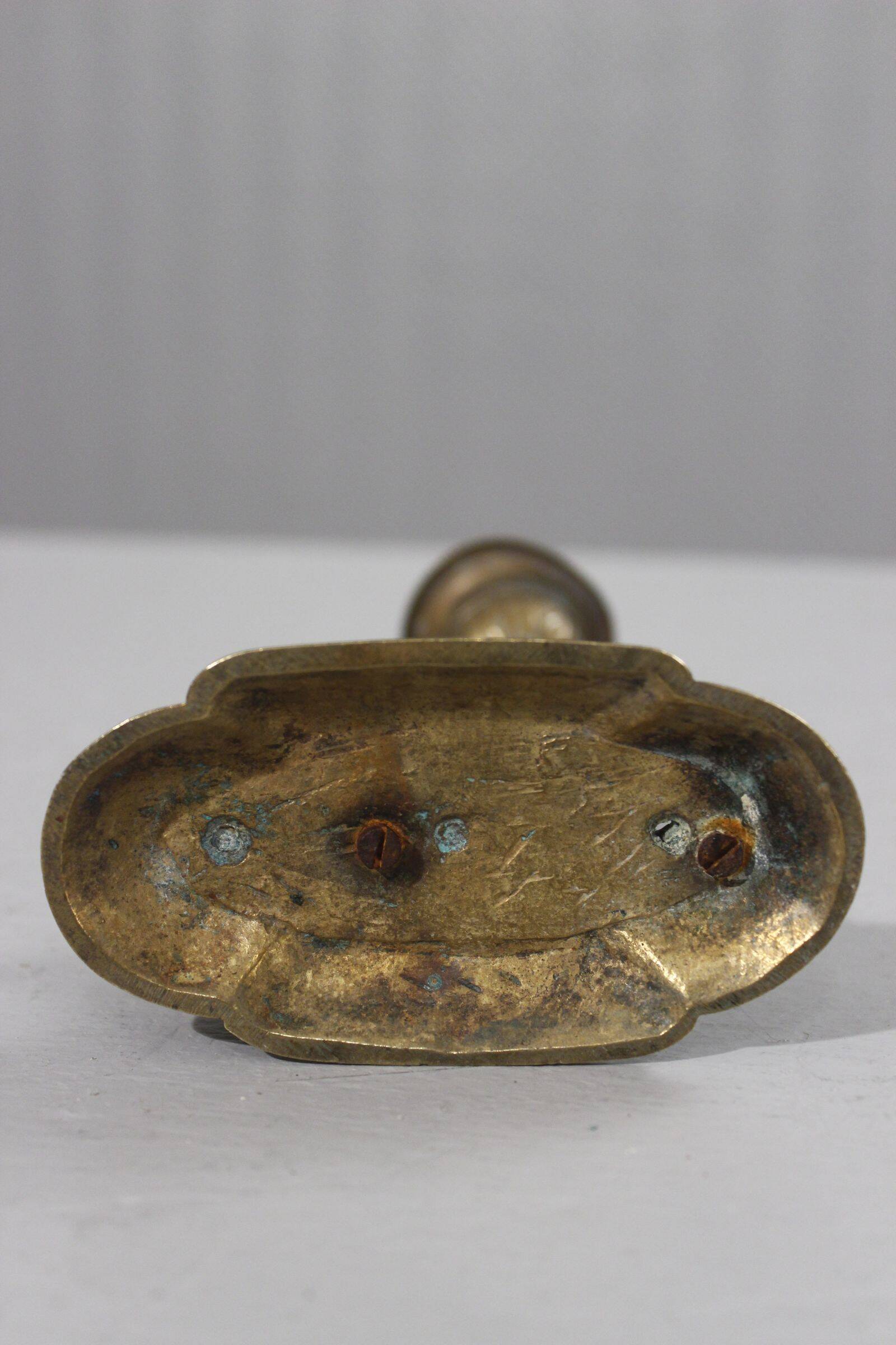 Handheld candlestick in bronze featuring a griffin, 19th-century Empire style.