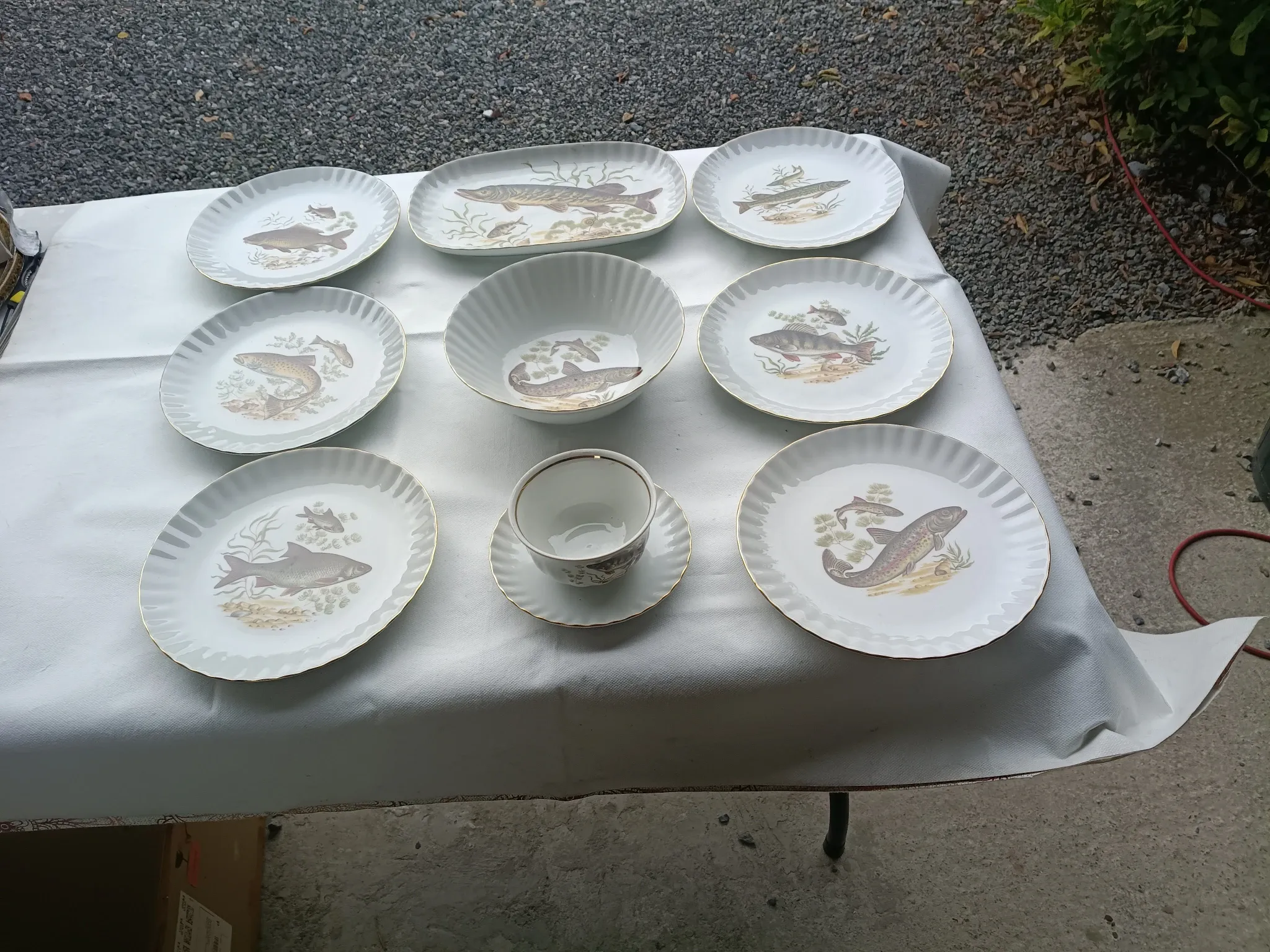 vintage porcelain dinner service with fish pattern and gold trim