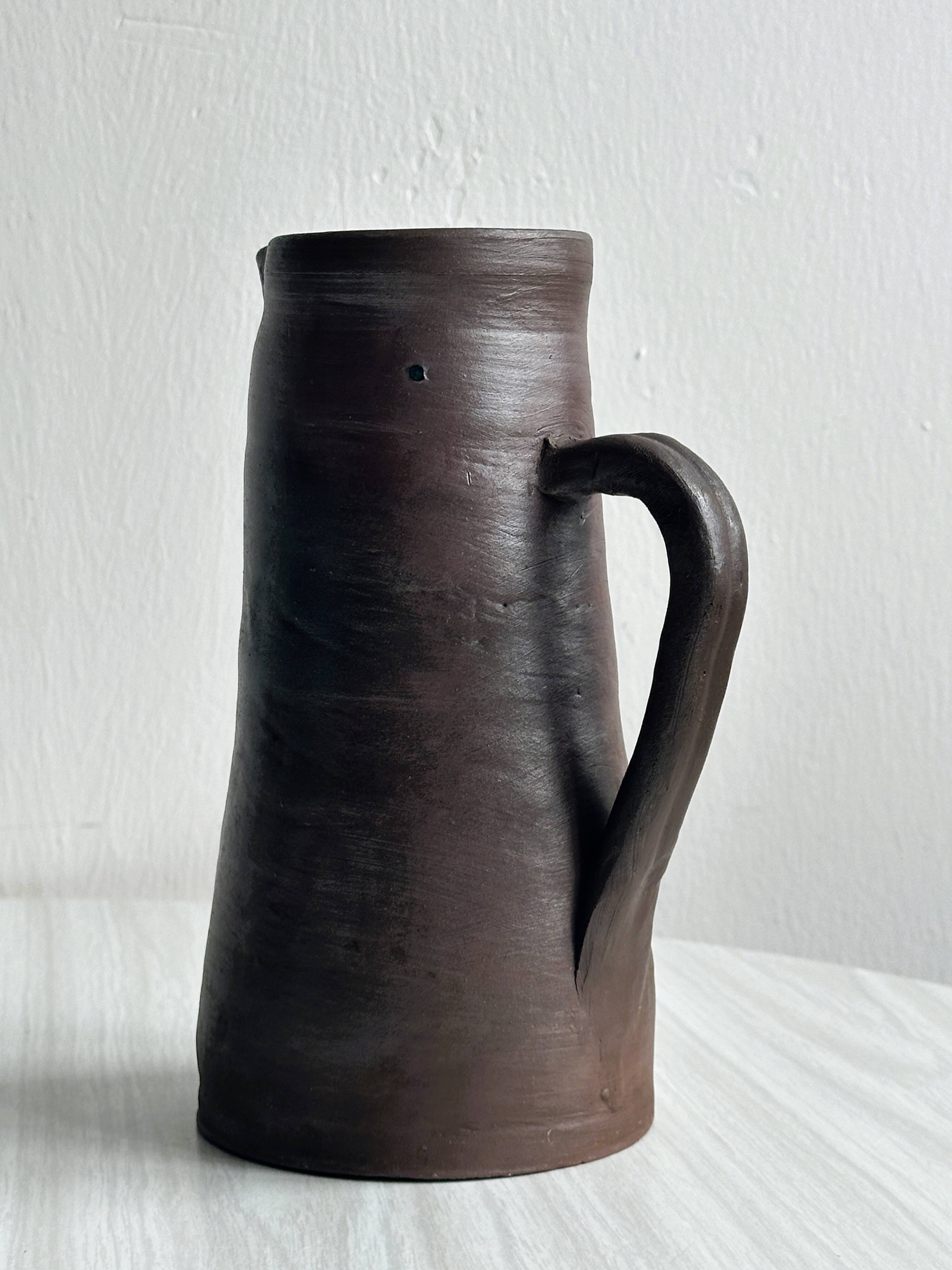 Pitcher, watering can in dark brown ceramic with matte finish.