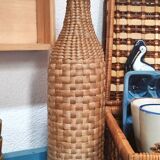 Green glass bottle and wickerwork