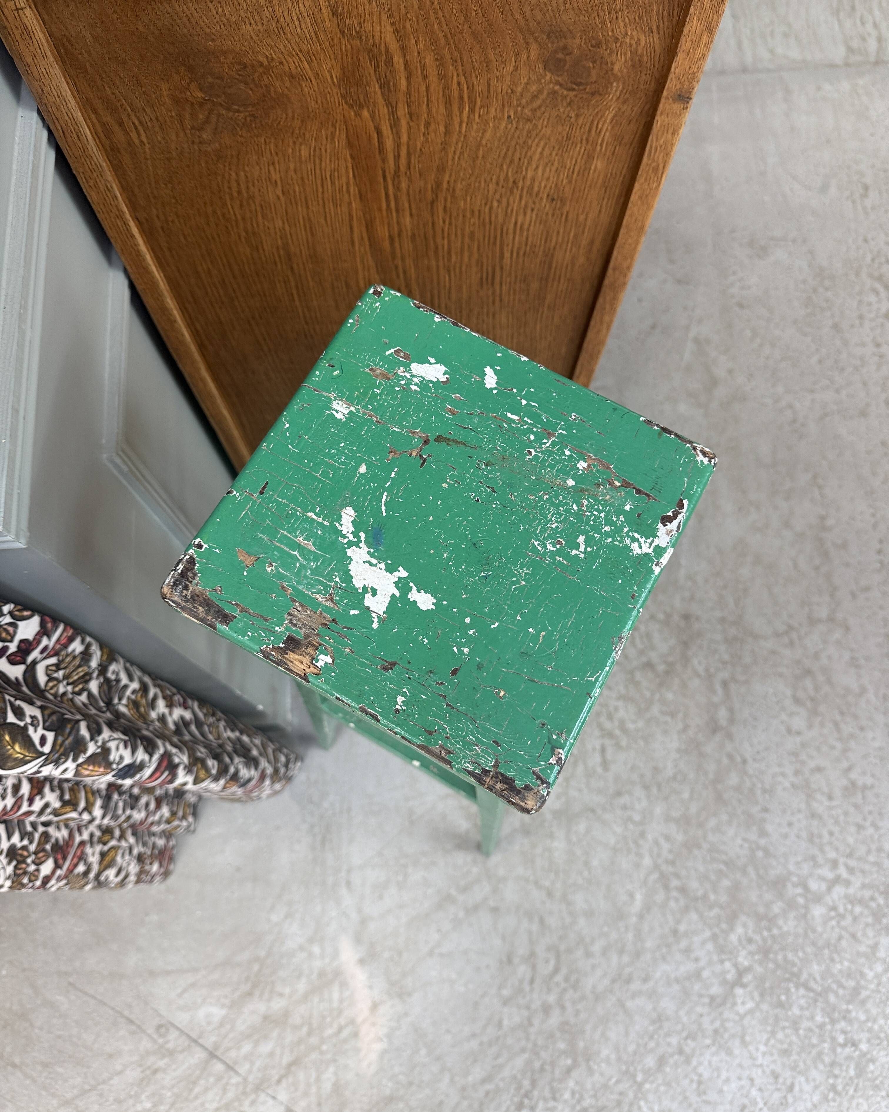 Vintage wooden stool with green patina.