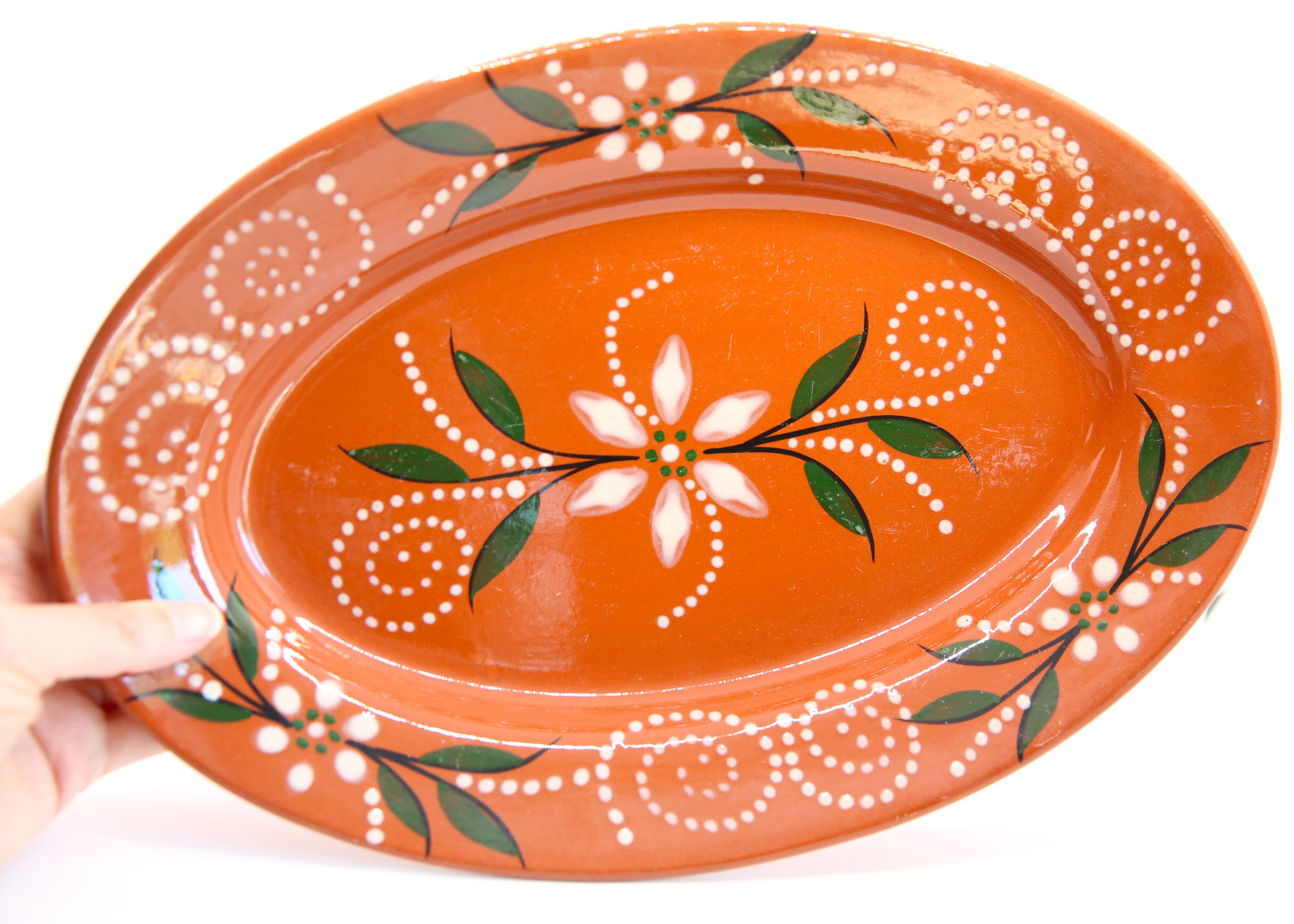 Portuguese XL dish in orange enamelled clay with unbleached flowers and green leaves
