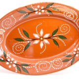 Portuguese XL dish in orange enamelled clay with unbleached flowers and green leaves