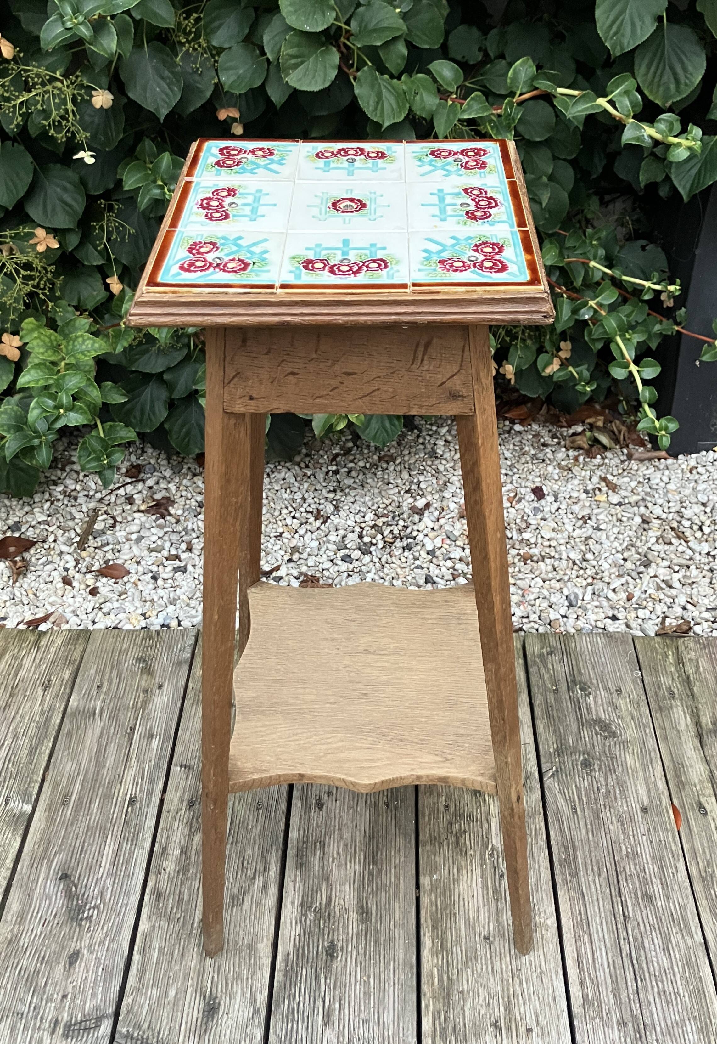 Antique wooden plant stand with ceramic tiles.