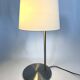 Large brushed metal table lamp with an ecru shade.