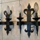 Pair of wrought iron wall lights in fleur-de-lis château style.
