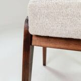 Pair of wooden stools with beige fabric.