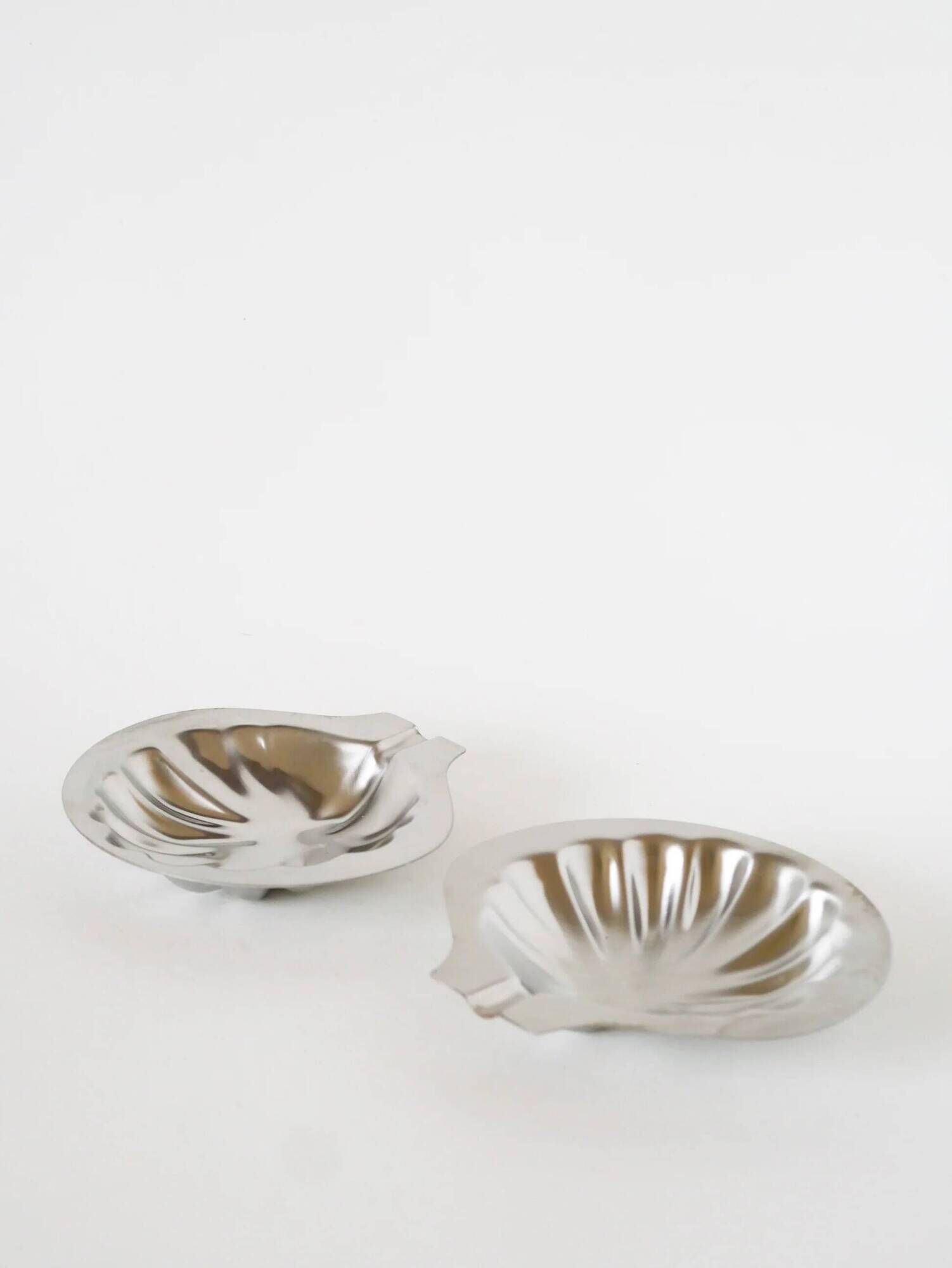 Pair of shell-shaped stainless steel catchalls, design, 1970