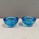A set of iitalla candle holders in blue transparent glass.