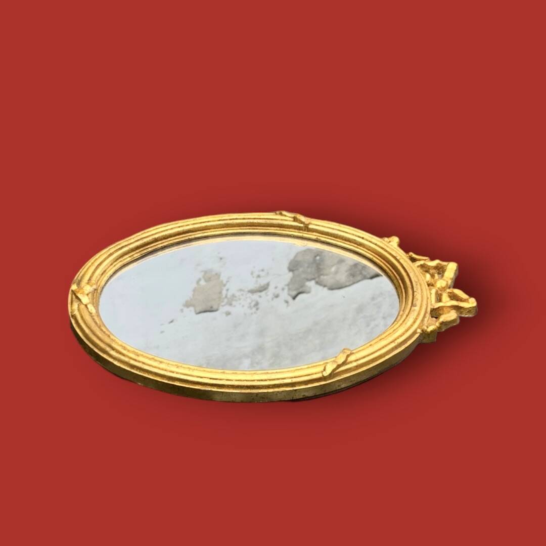 Antique oval mirror in gilded resin with Louis XVI style knot decoration
