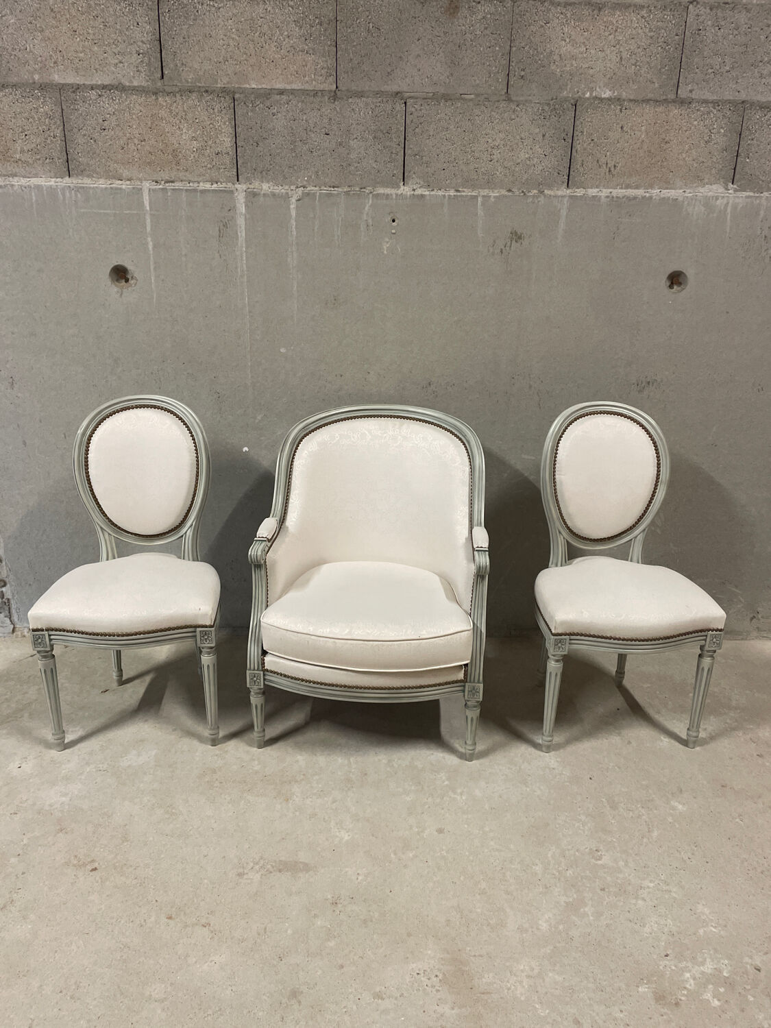 Armchair and 2 chairs set in Louis XVI style, light fabric, patinated wood.