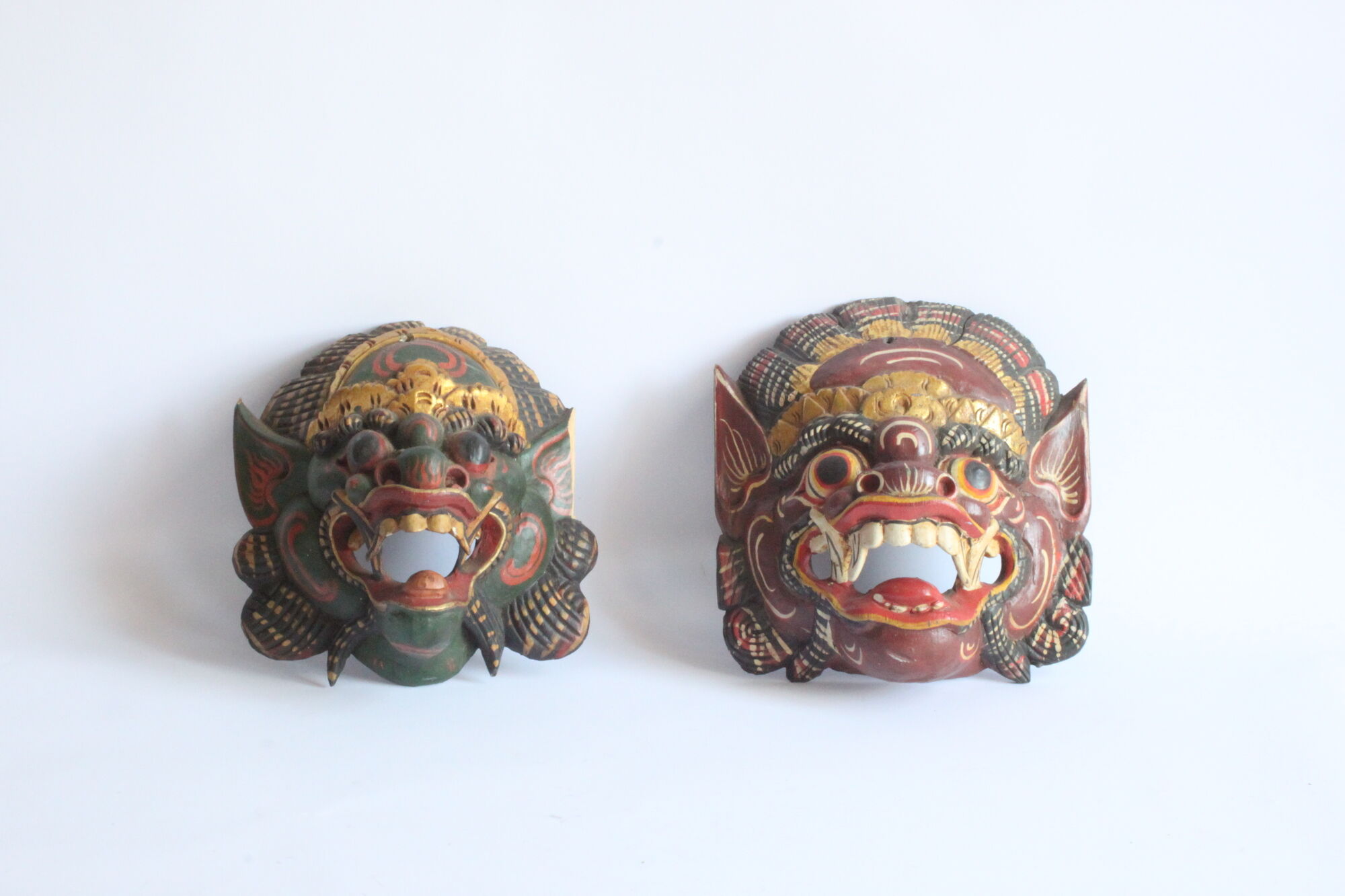 Two polychrome painted and gold leaf gilded Barong dance masks from Bali, Indonesia.