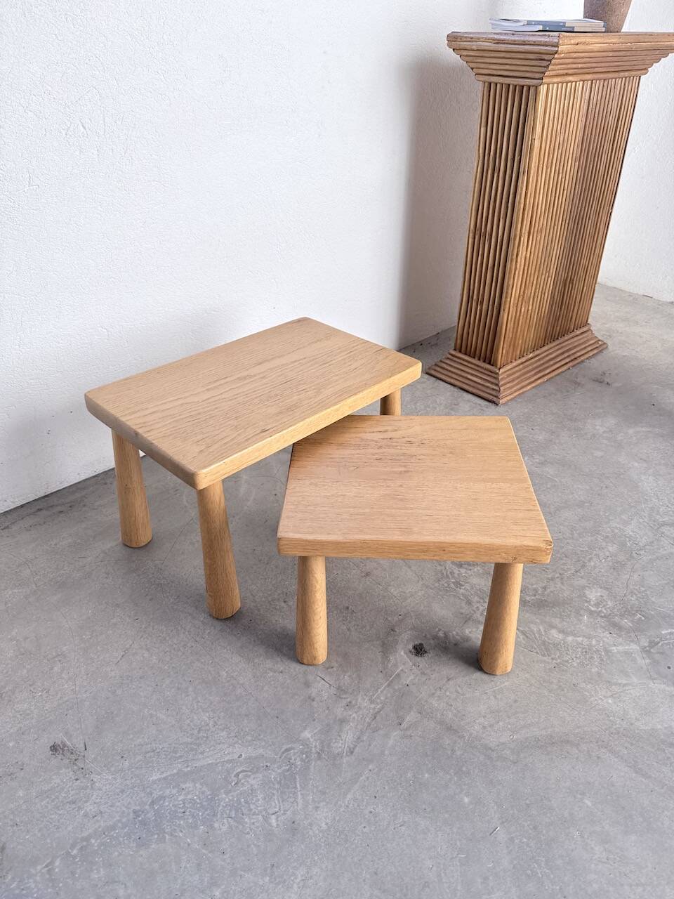 Two stools or small nesting tables in light oak.
