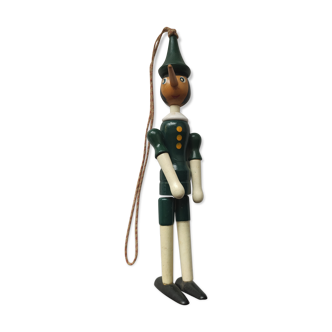 Green pinochio puppet in old wood