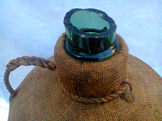 Demijohn dressed in burlap and padded cork