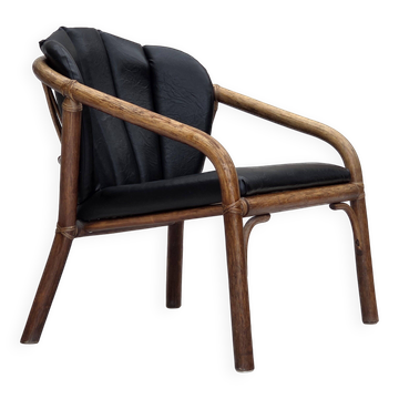 Fauteuil danois des années 1970, en rotin, en simili cuir noir.