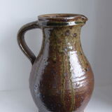 Old pitcher in brown sandstone with green drippings