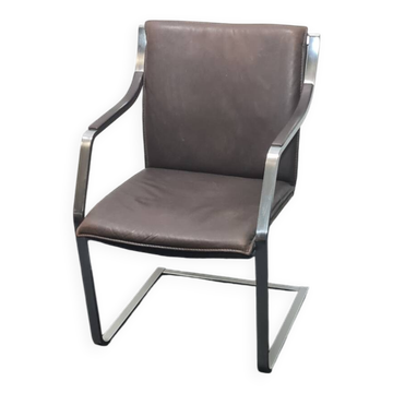 One of two vintage Leather and metal arm chairs.