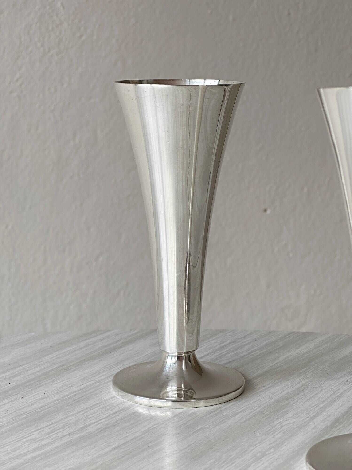 Two silver-coloured lightweight metal flower vases.