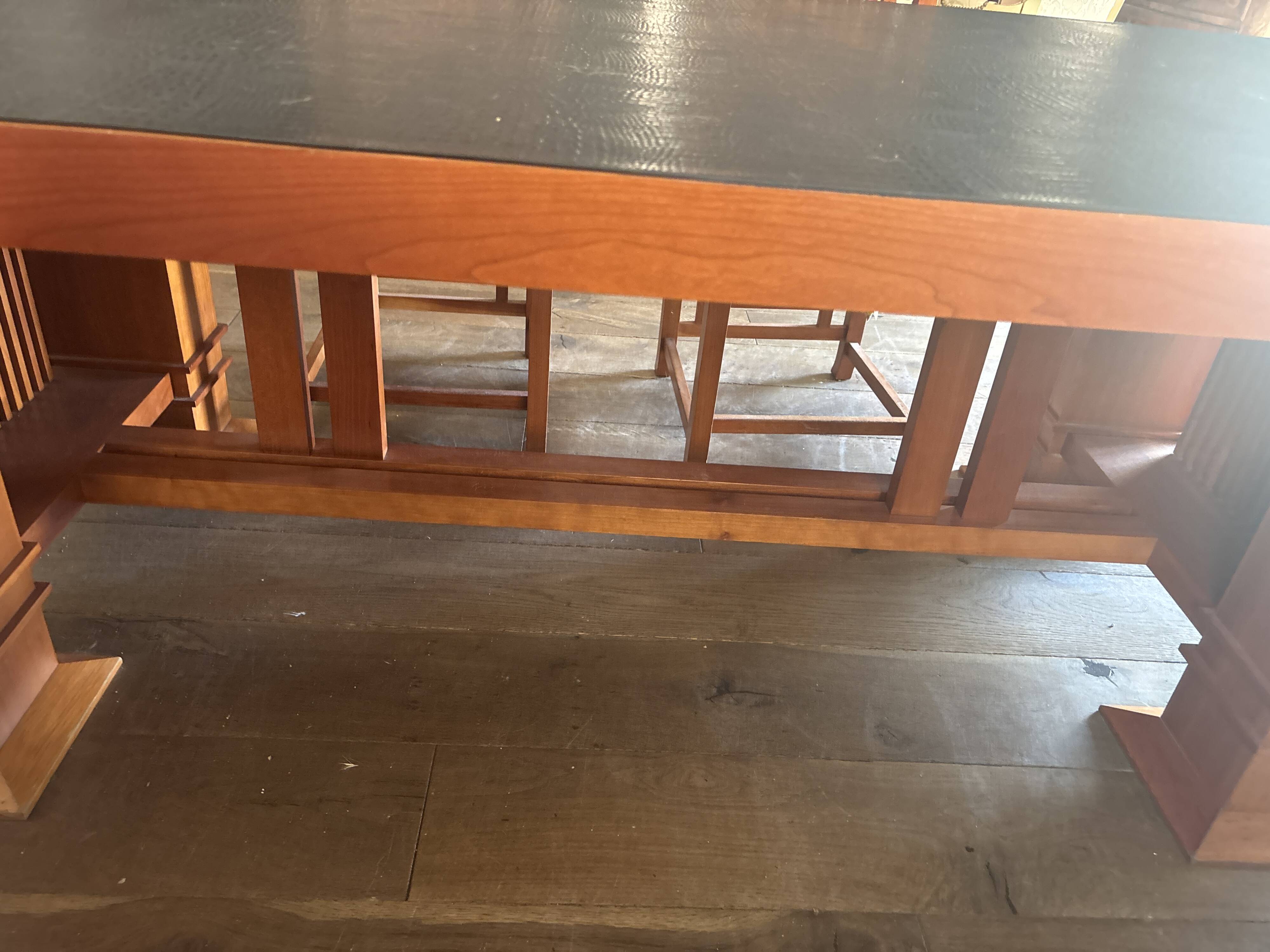 "Frank Lloyd Wright set with a table and its eight chairs."