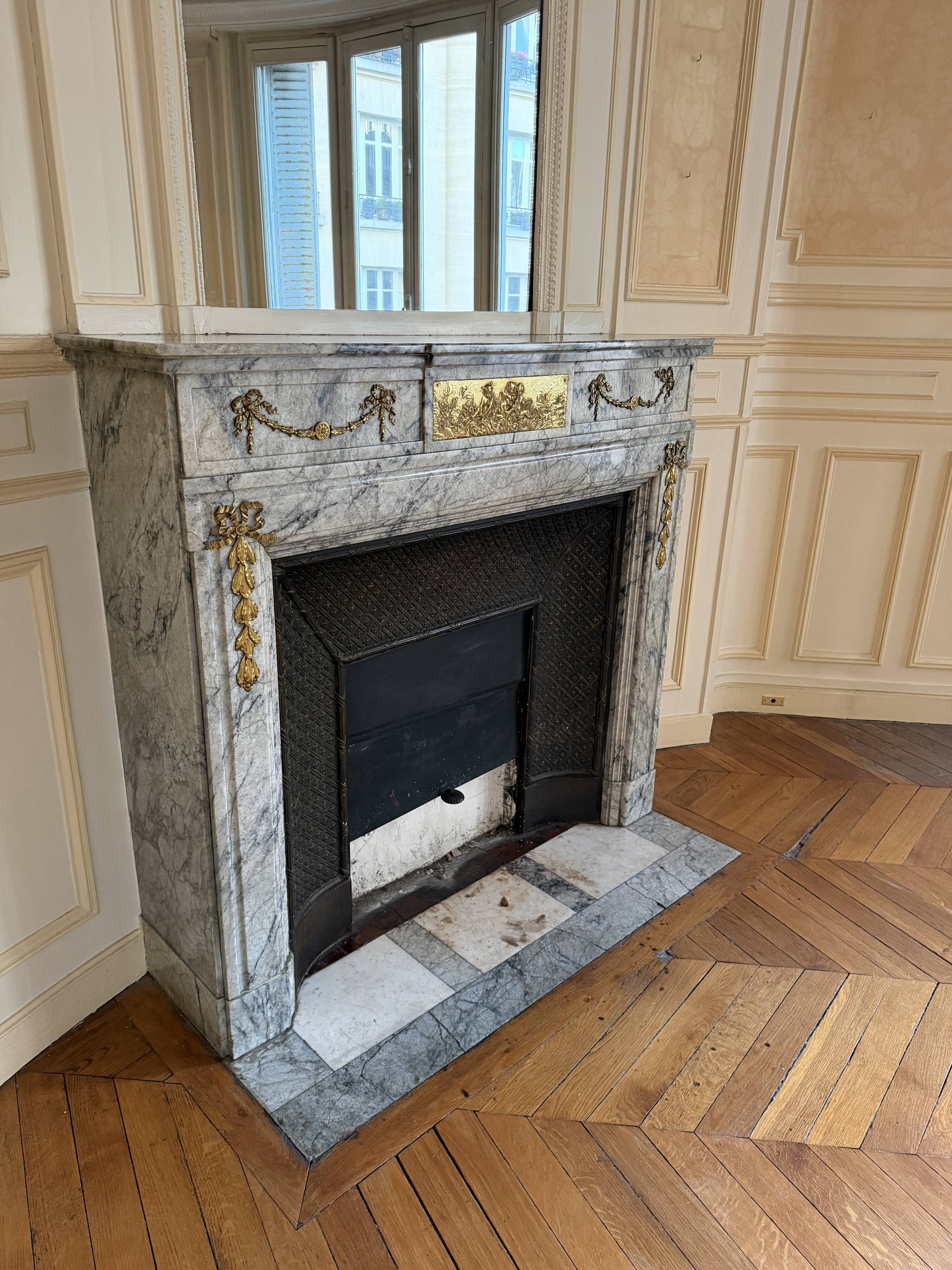 Louis XVI fireplace in veined grey marble with original gilded bronzes from the 19th century.
