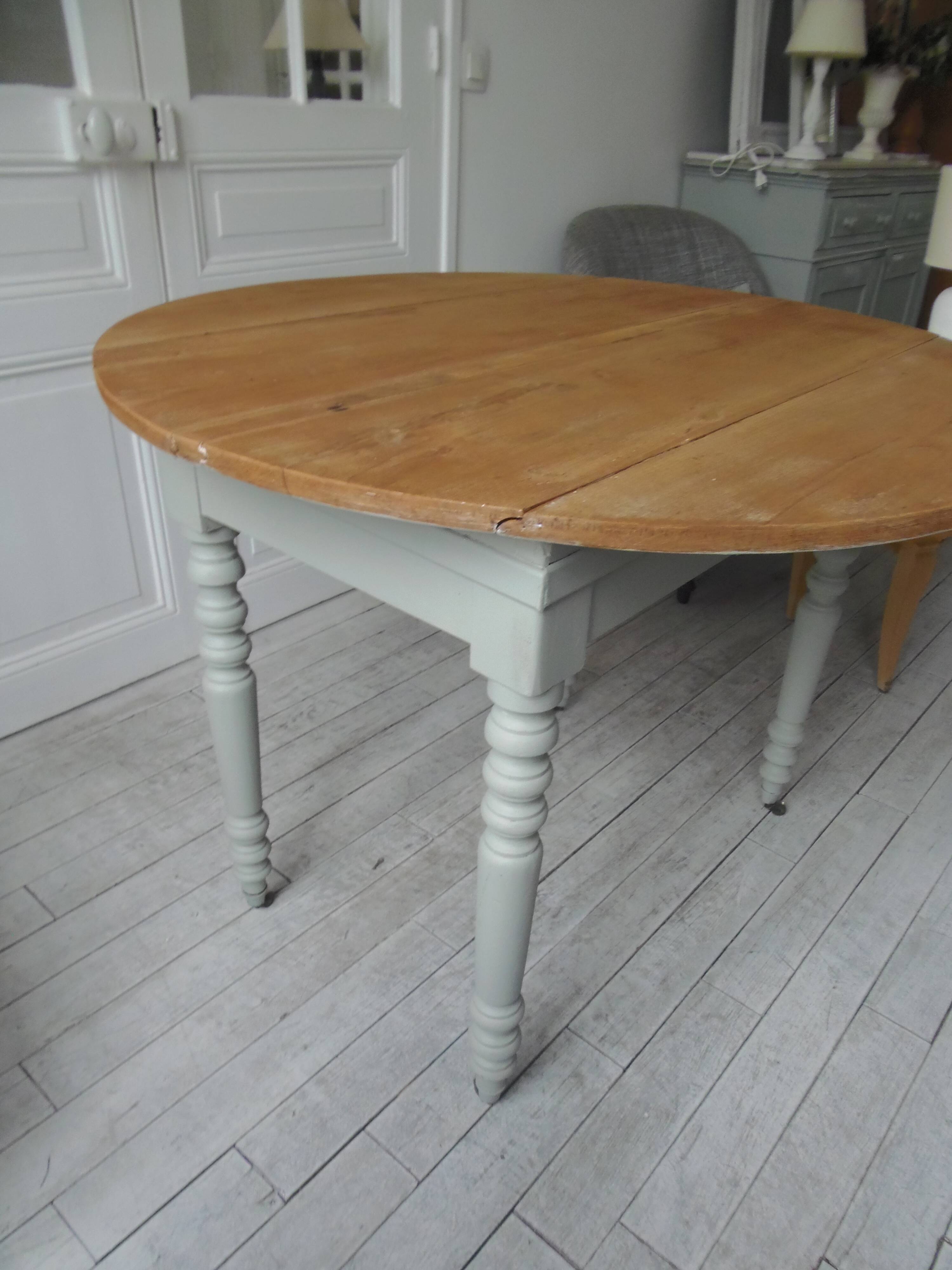 Raised walnut table with drop-leaf top, base on verdigris castors.