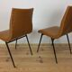 Pair of 1950s chairs with compass legs and brown faux leather.