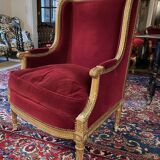 Golden wooden bergère in Louis XVI style upholstered in Bordeaux velvet.