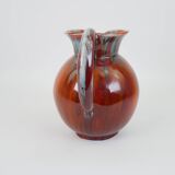 Large red and blue glazed ceramic pitcher signed Delène under the base