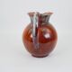 Large red and blue glazed ceramic pitcher signed Delène under the base