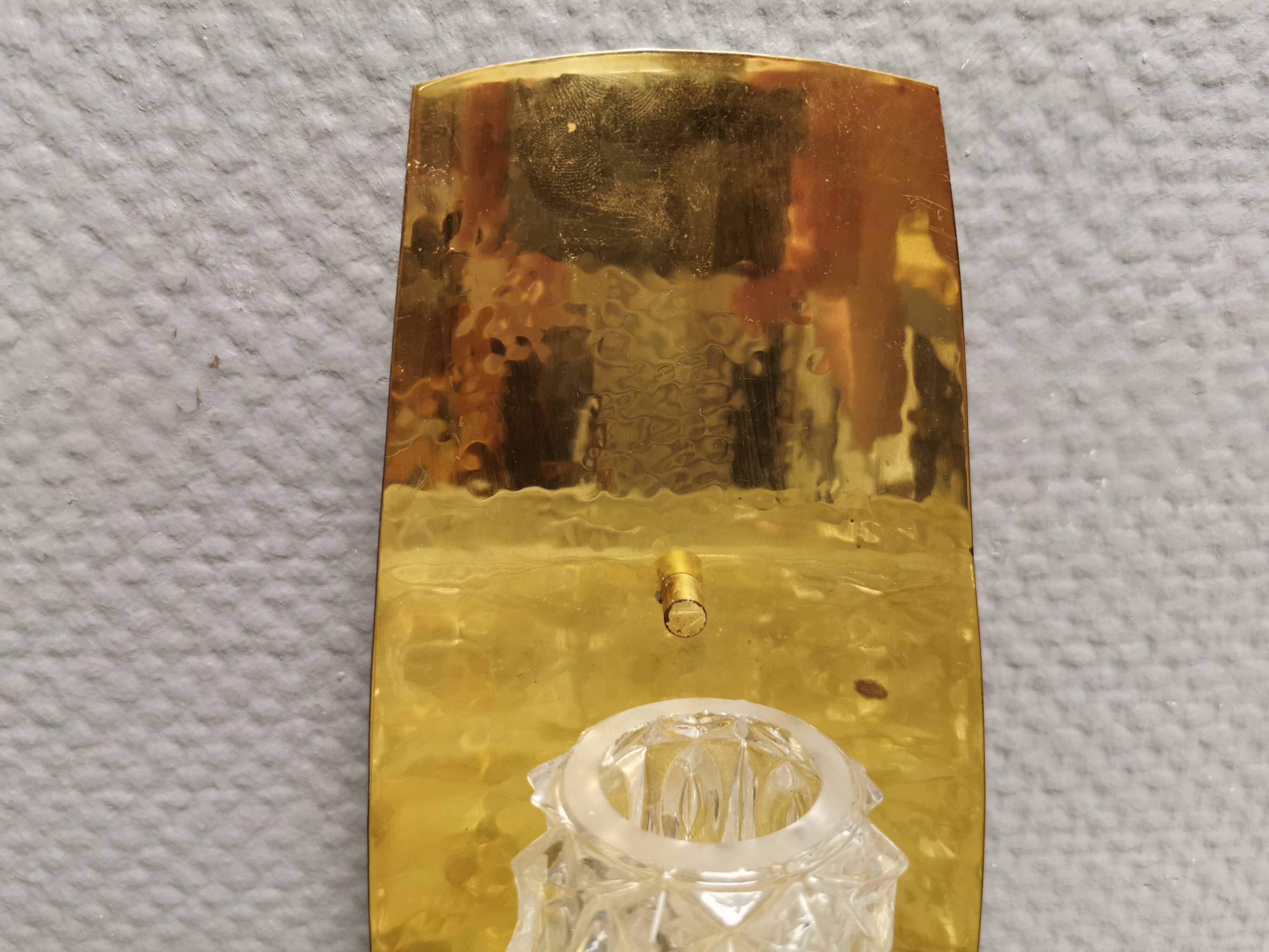 Older wall lamp in brass with hard pressed glass shade.