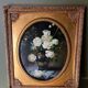 Large still life with white roses in an old gilded oval frame.