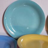 Seven pastel-colored plates mixed with vintage earthenware