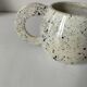 Small speckled ceramic jug in a vintage workshop style.