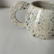Small speckled ceramic jug in a vintage workshop style.