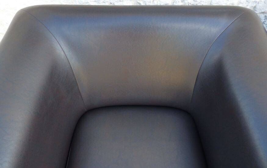 2 club armchairs with a chocolate faux leather seat and backrest and wooden legs.