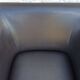 2 club armchairs with a chocolate faux leather seat and backrest and wooden legs.
