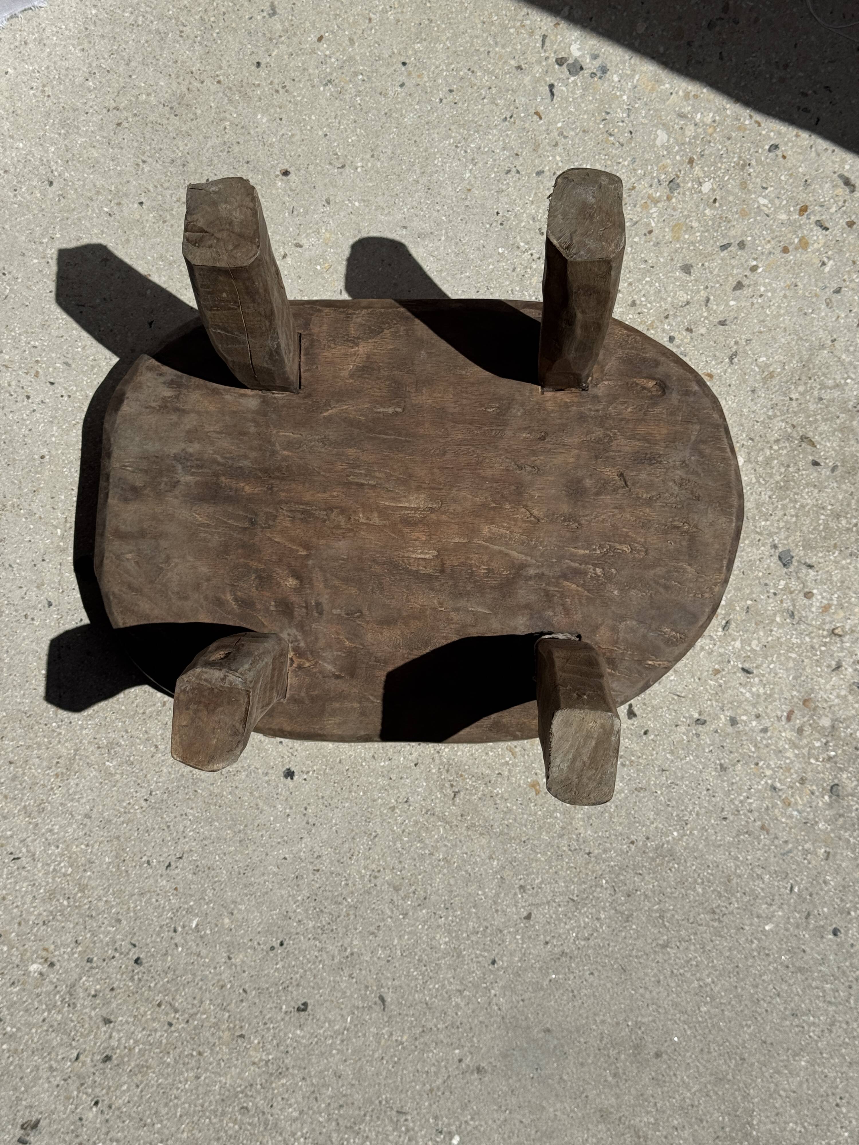 Small stool, oval solid teak side table with curved legs in wabi-sabi style.