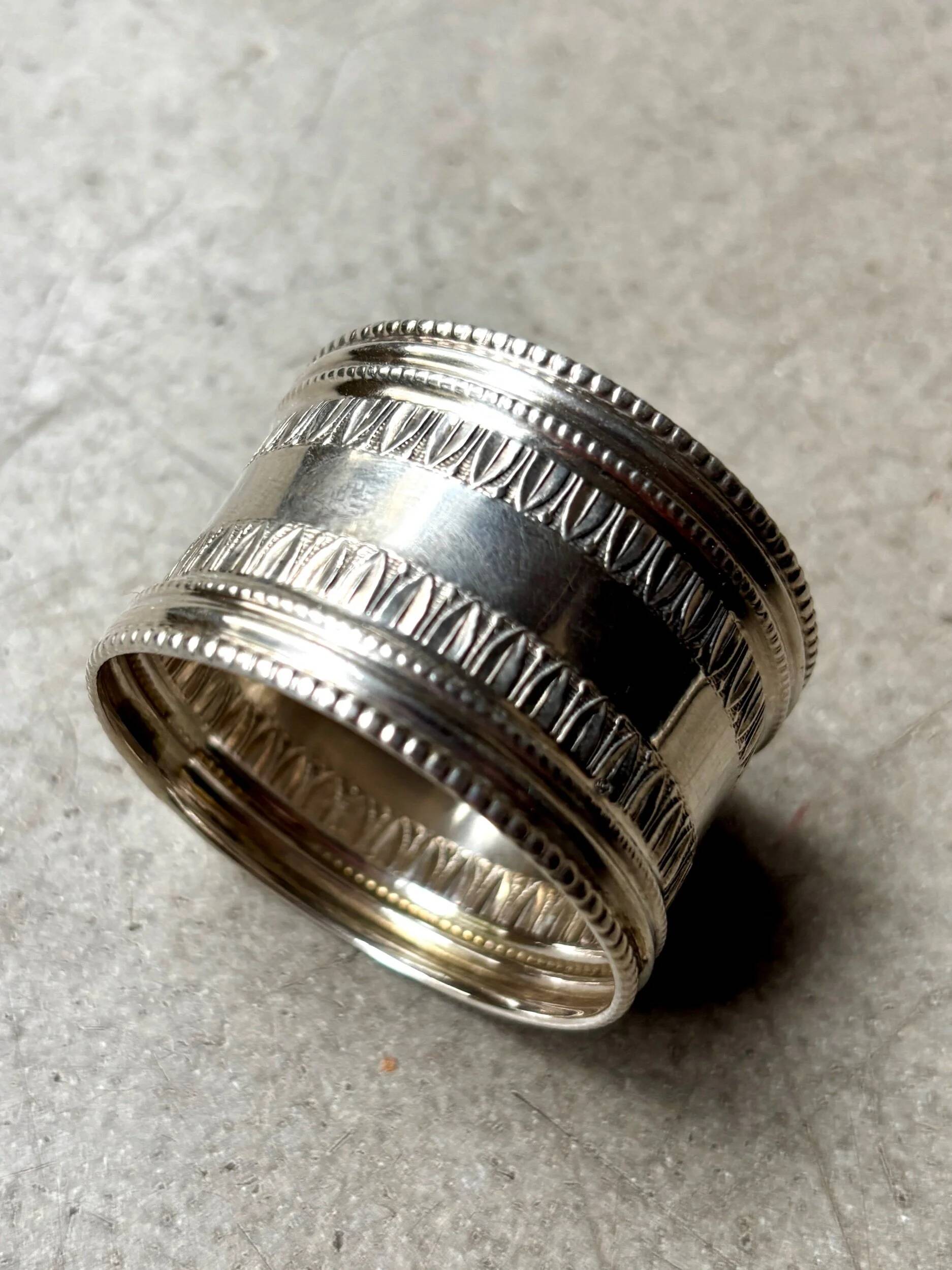 Monogrammed silver napkin ring with palmette and beaded motifs